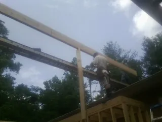 Carpenter setting a ridge beam over a new addition frame — Ice Dam Removal by Roofing Brothers in Lee