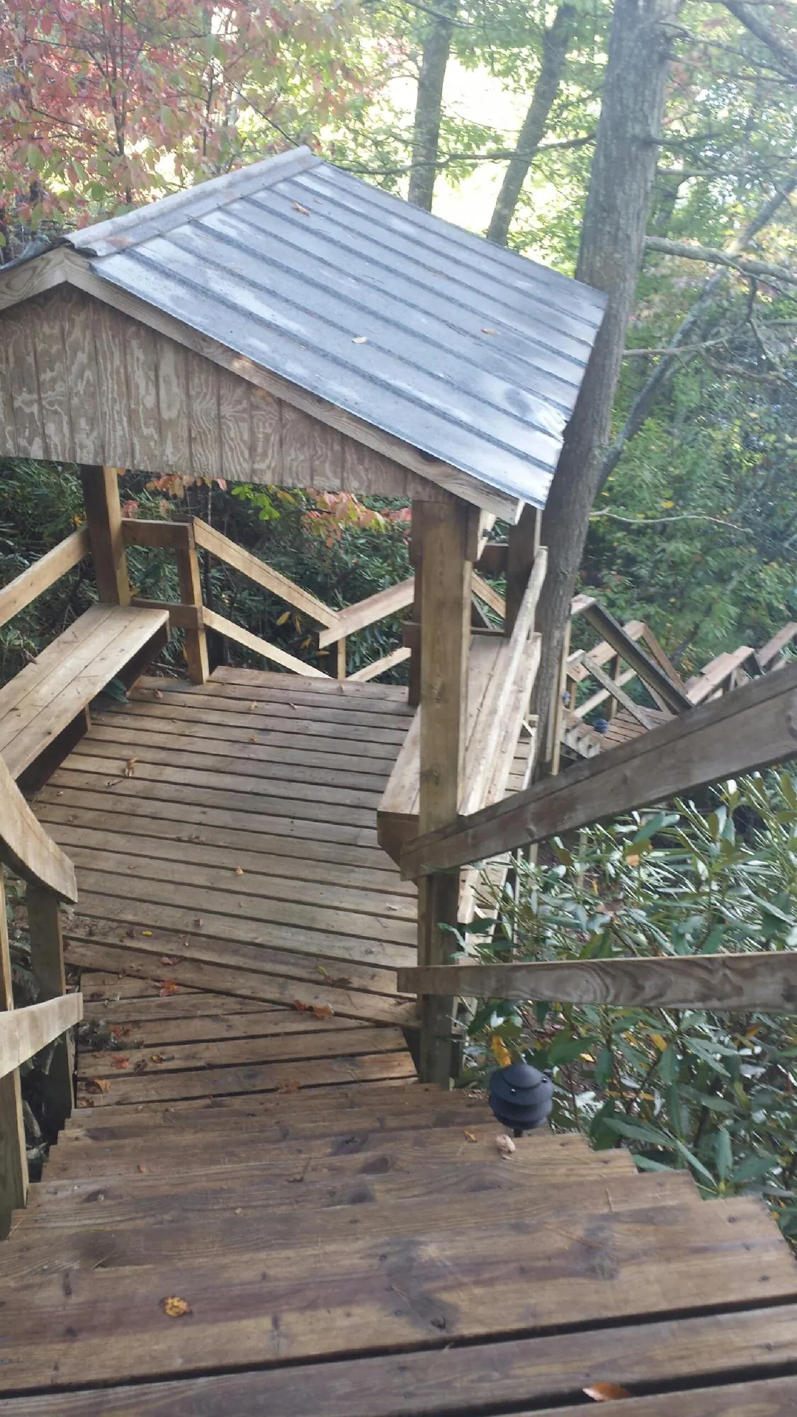 Metal roofed shelter over wooden steps on a wooded walkway — Skylight Repair & Installation work by our crew in Lee