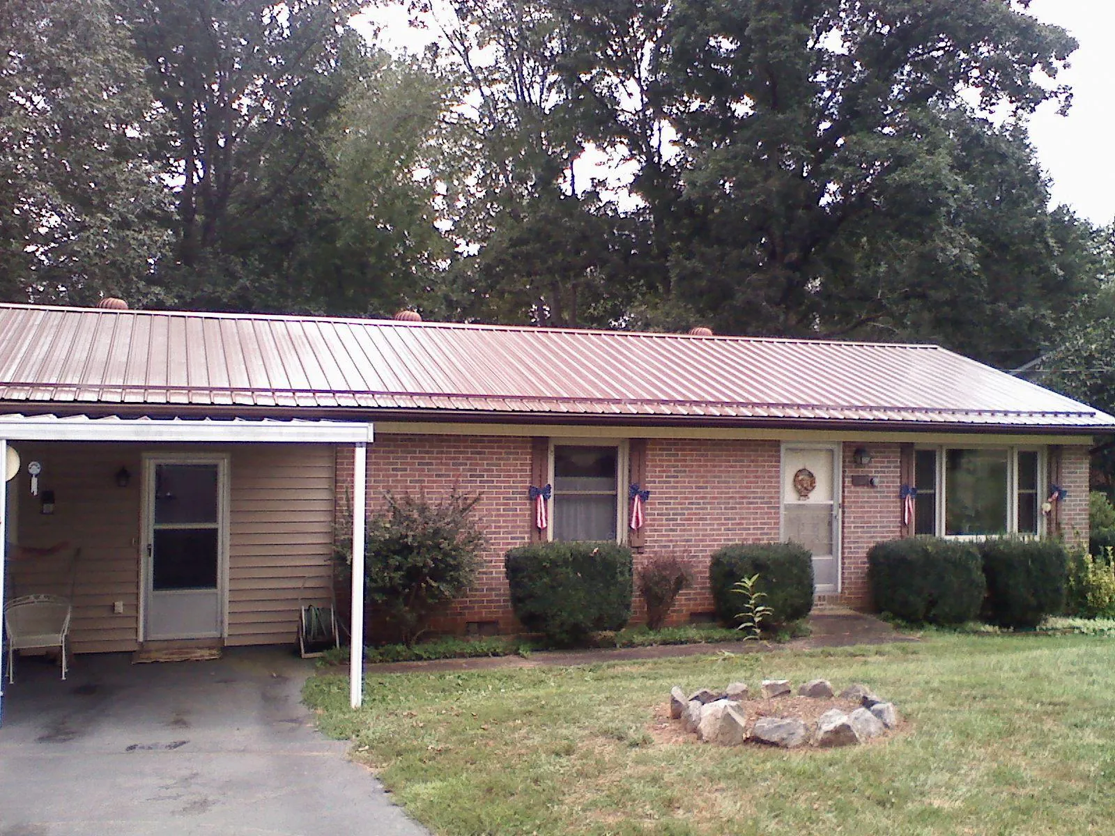 Bronze metal roof and carport on a brick ranch home — Roof Repair work by our crew in Lee